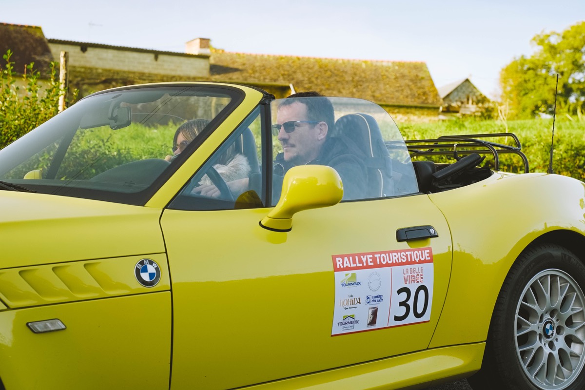 Conducteur au volant de sa voiture jaune pendant La Belle Virée