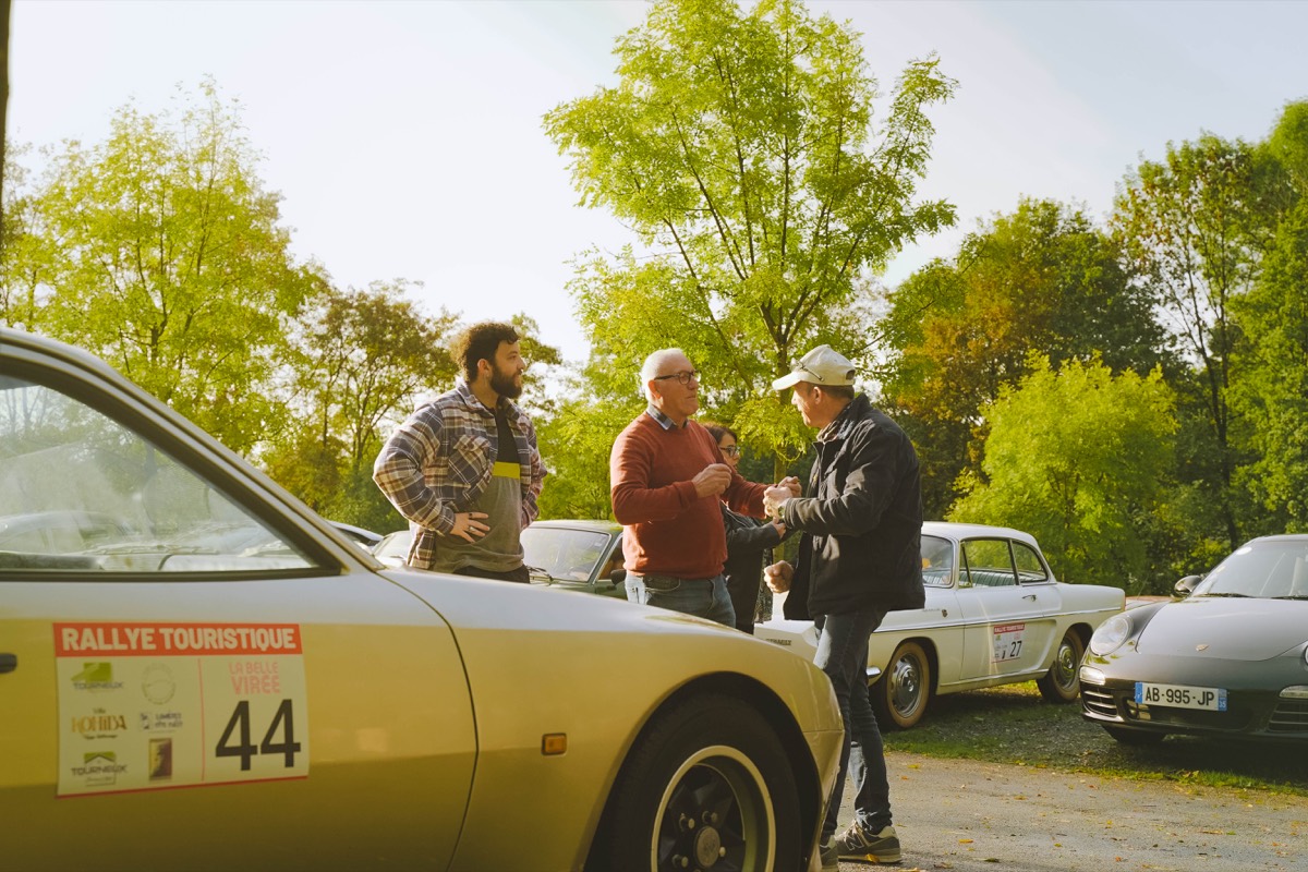 Participants échangeant autour d’une automobile ancienne